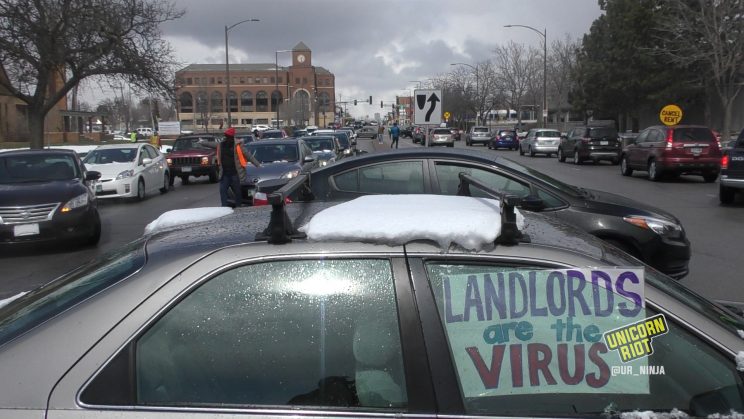Sign in car says "landlords are the virus"