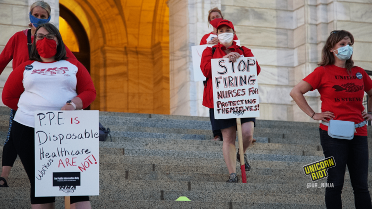 image: Five women participants stand on the steps in front of the main entrance to the Minnesota Capitol. One holds a sign, "Stop Firing Nurses for Protecting Themselves!" Another holds a second sign, "PPE Is Disposable, HealthCare Workers Are Not!"