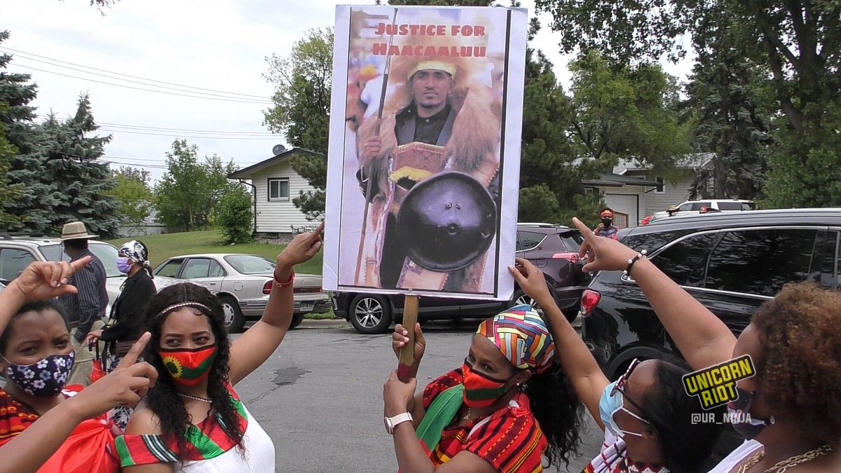 Oromo women point to a poster of Hachalu Hundessa before the August 7 Women’s March