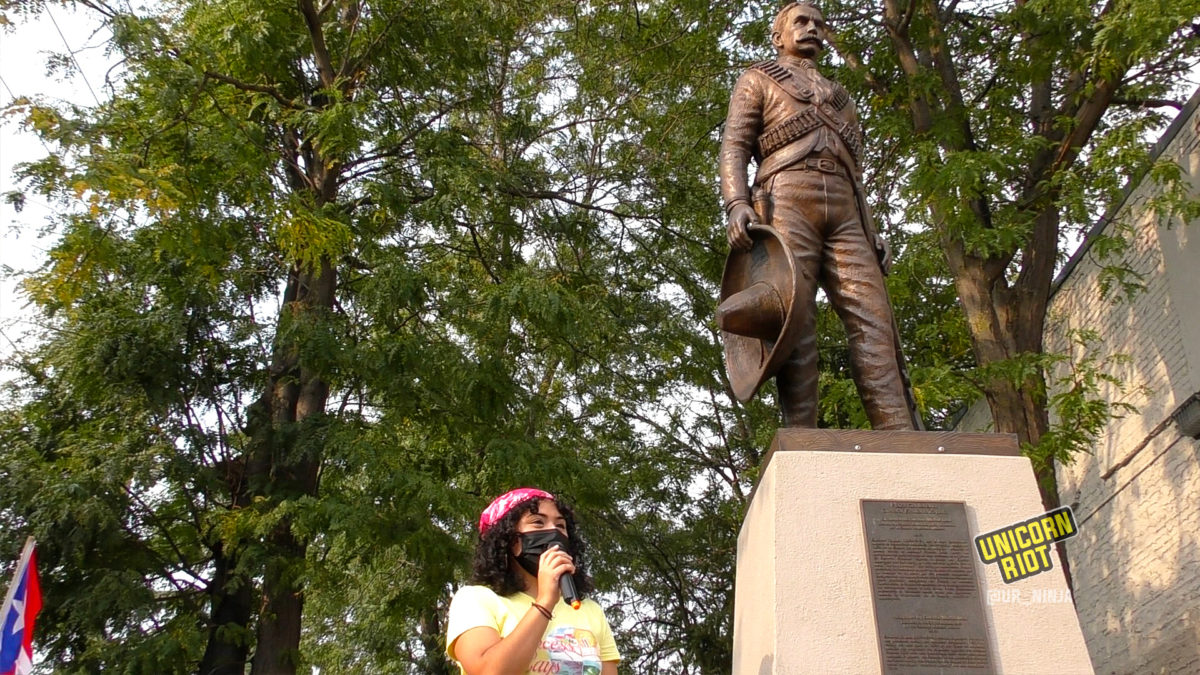 organizer speaks in front of Zapata statue