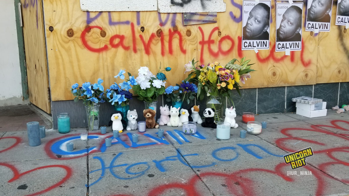 Candles mark where Calvin Horton lay after he was shot