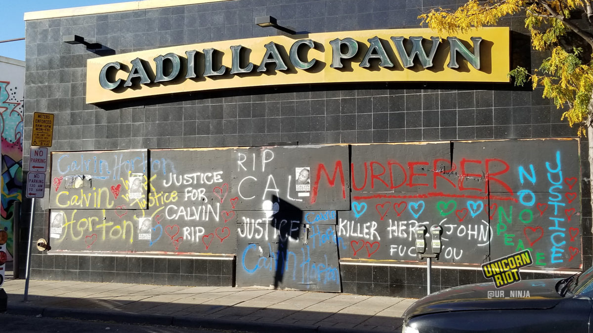 boarded up windows at Cadillac Pawn are spray painted with Justice for Calvin Horton and