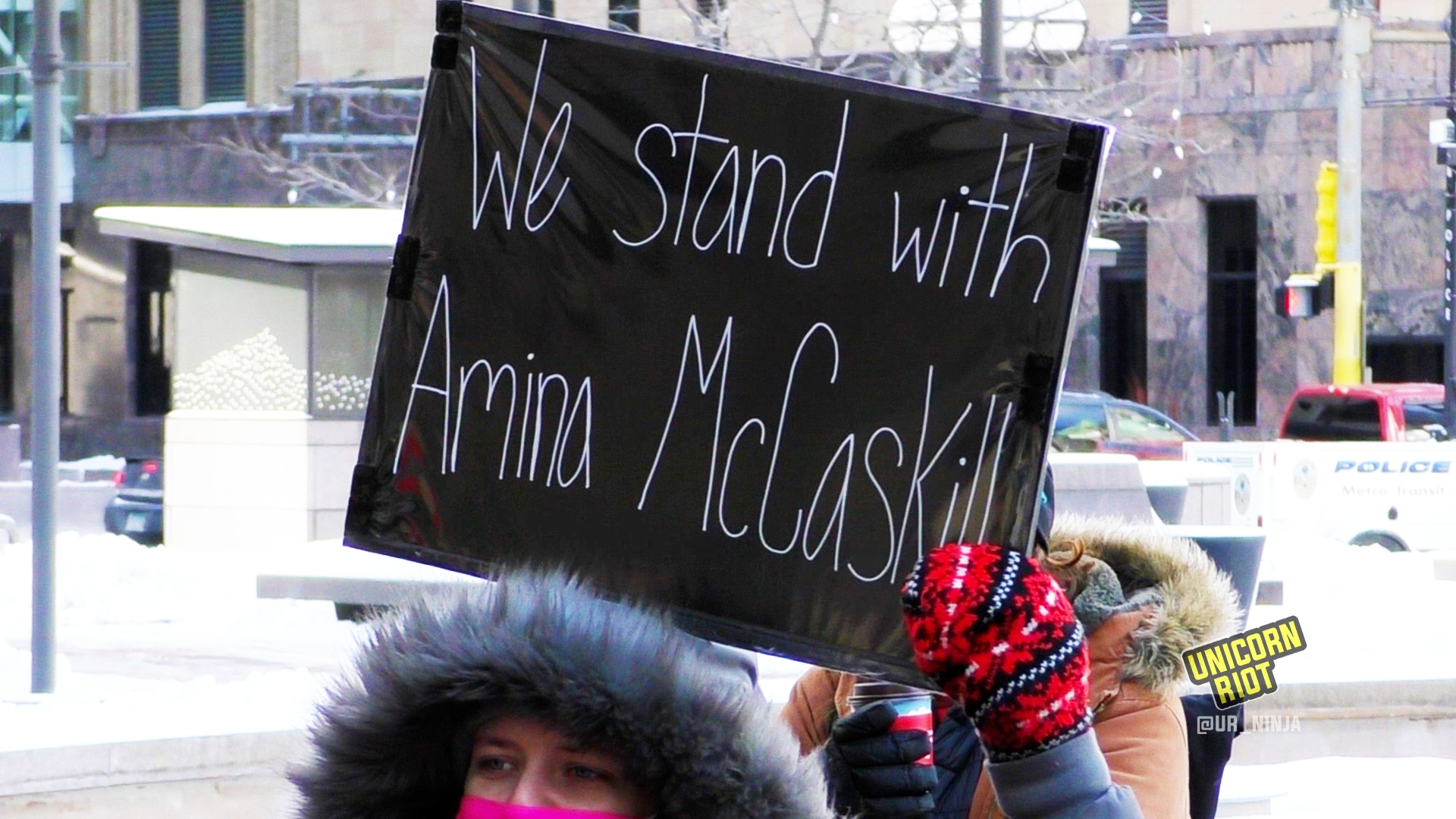 Sign reads "we stand with Amina McCaskill"