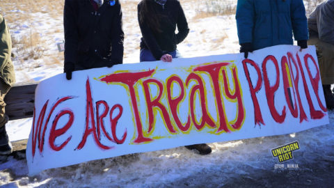 Water Protectors holding banner that says, "We Are Treaty People."