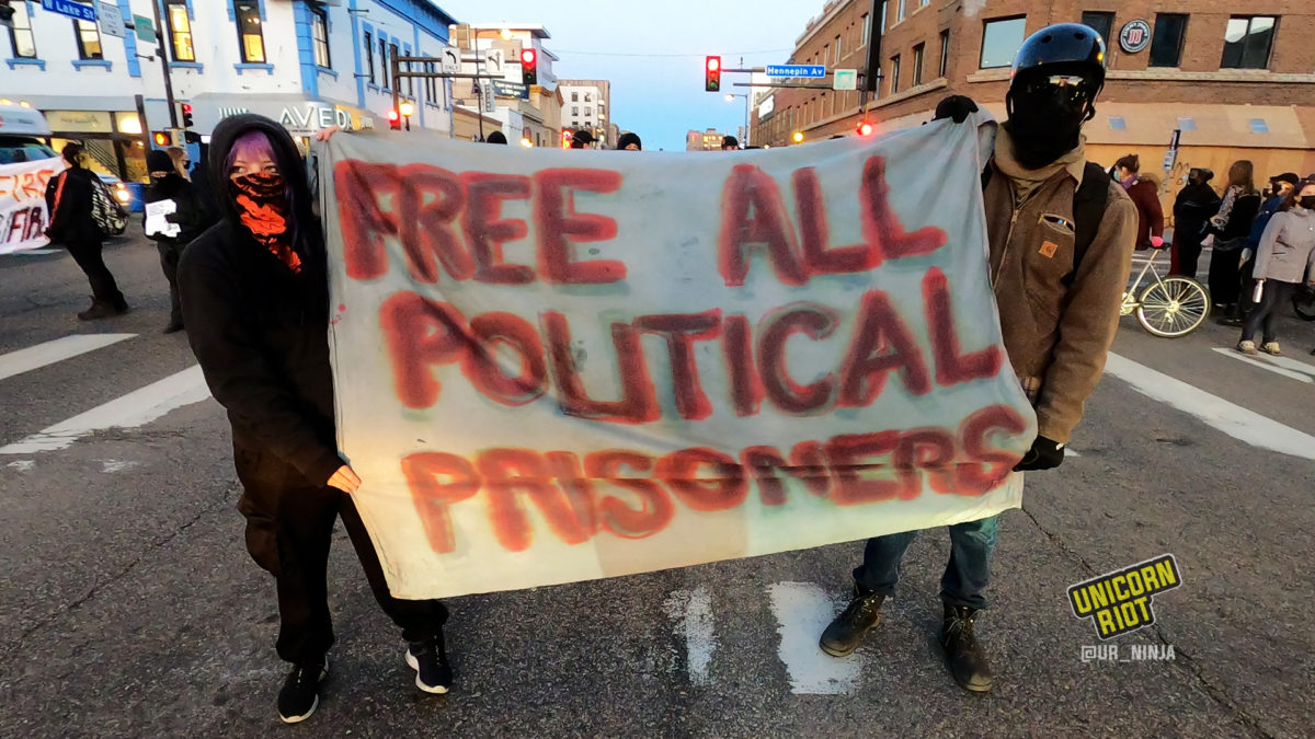 banner reading 'free all political prisoners' was held while housing activists blocked Hennepin Ave