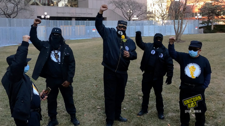 black panther party members and yellow panthers raise their fists outside the hennepin county government center