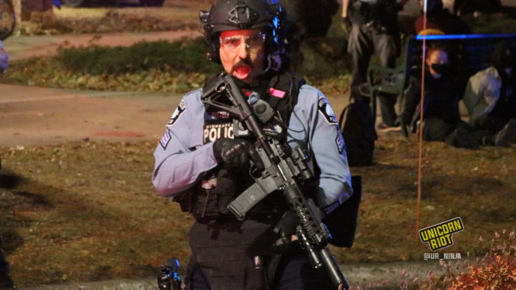 Sergeant Andrew Bittell holding an assault rifle as MPD officers make arrests during an election night dance party