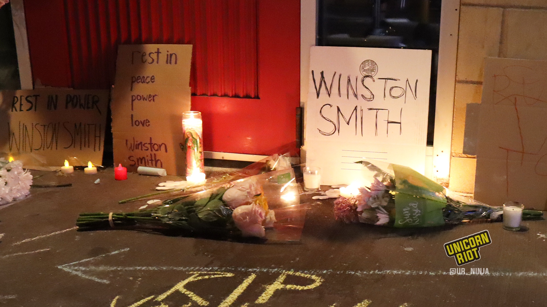 Flowers and signs placed on the sidewalk near the parking ramp where Smith was killed - June 4, 2021