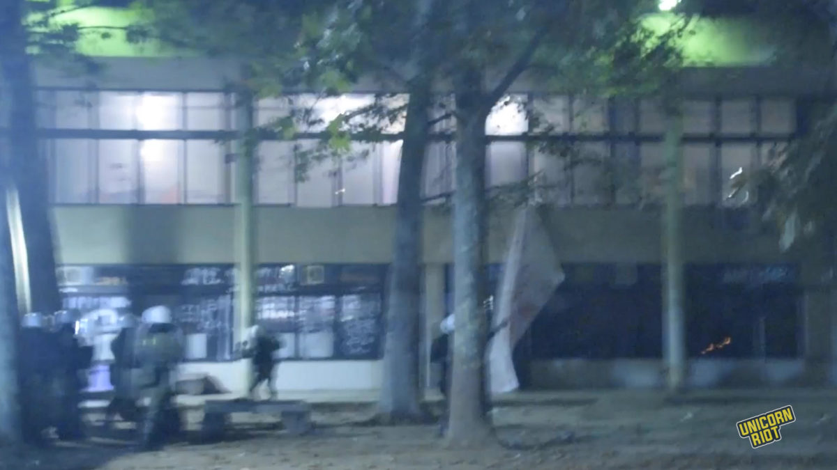 Riot police throw tear gas and flashbang grenades into a building at the Polytechnic University on Nov. 17, 2022, during heavy clashes after the main demonstration against the former ruling military junta.