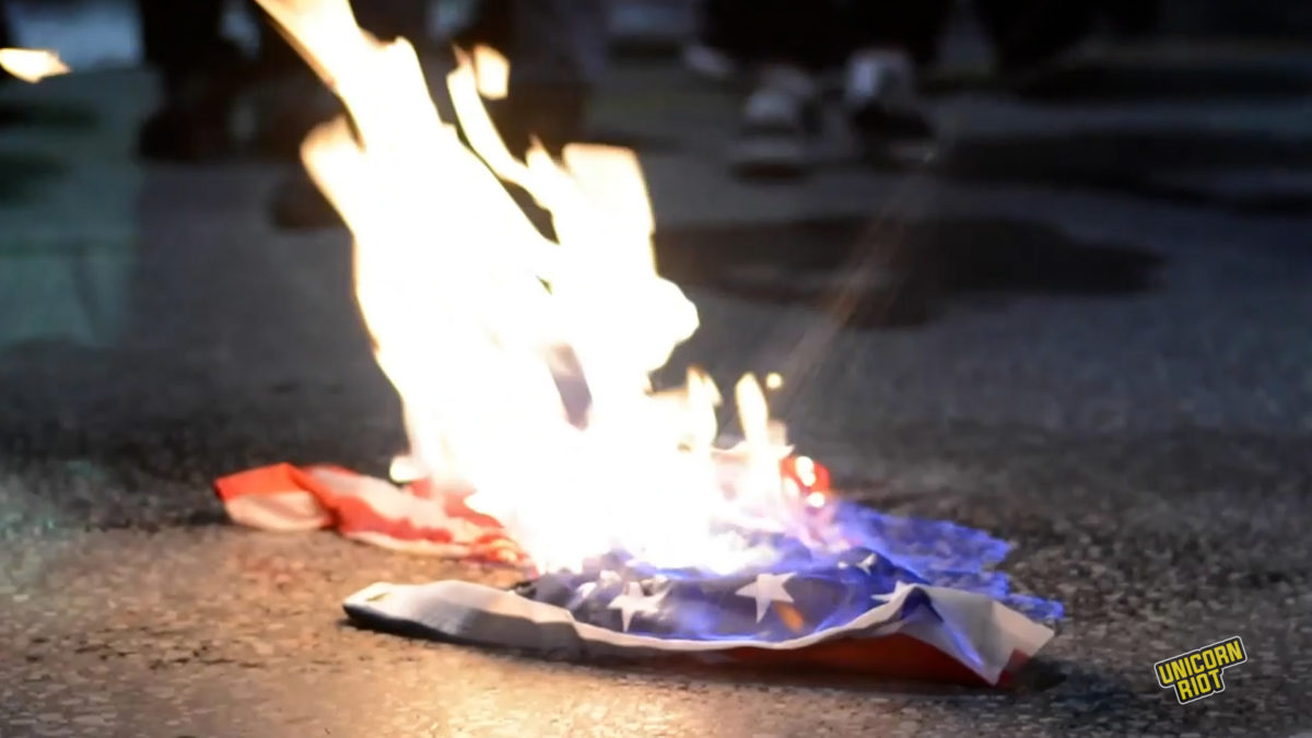 Flag of the United States is burned during the Nov. 17, 2022, demonstration against the former ruling military junta. The U.S. government supported the military coup in 1967 and the junta that followed.