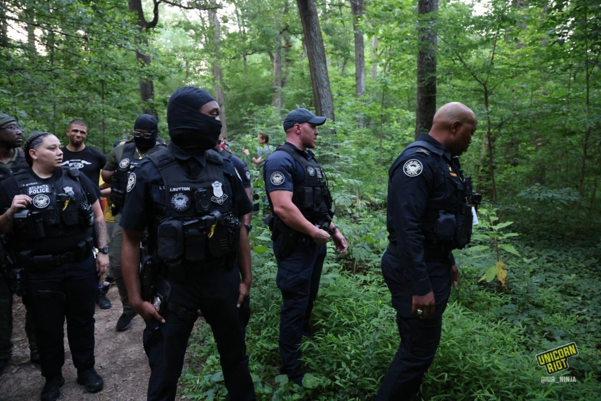 Atlanta Police officers in tactical vests and sweep through the park as the vigil for Manuel ‘Tortuguita’ Terán was set to begin at 8:30 p.m. - a commanding officer is seen looking into the woods off the path area to identify tents